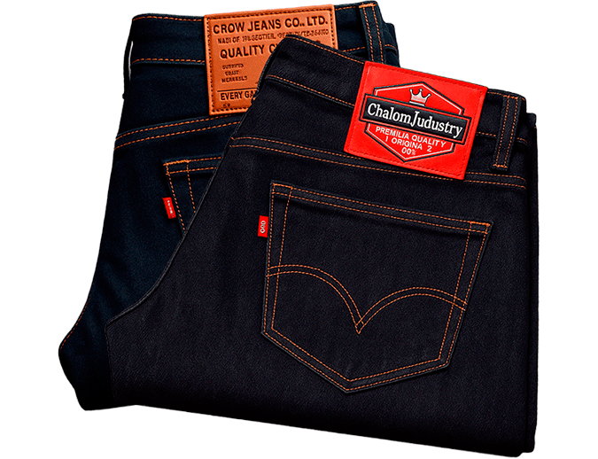 Par de jeans denim con garras de cuero genuino y placas metálicas anticorrosión de alta resistencia, fabricados al por mayor en Bogotá.