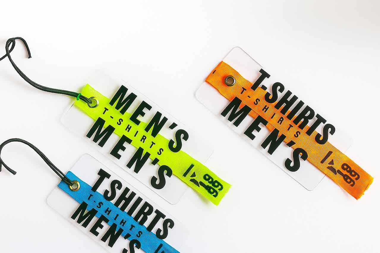 Marquillas y etiquetas de cartón con acetato transparente y cinta reata de colores para ropa de moda.