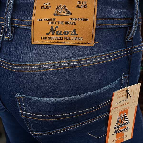 Marquilla en cuero sintético con acabado quemado sobre jeans azul